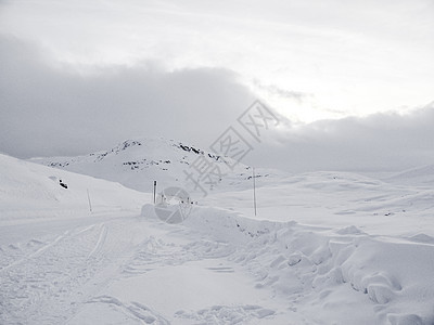 在挪威的雪路和风景中行驶乡村运输木头森林季节国家暴风雪小路天气旅行图片