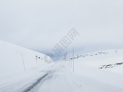 在挪威的雪路和风景中行驶运输天气国家木头森林小路交通旅行乡村暴风雪图片