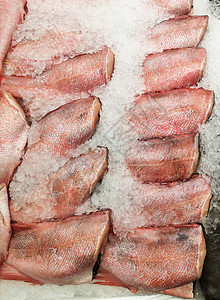 一家冷冻的剥皮无头鱼 躺在商店橱窗 柜台的冰面上图片