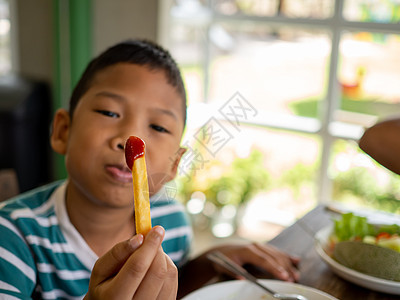 炸薯条加番茄酱 在男孩手里营养饭馆桌子垃圾乡村女士食物盘子享受烹饪图片