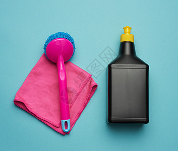 粉红色抹布和塑料清洁刷 黑塑料瓶图片