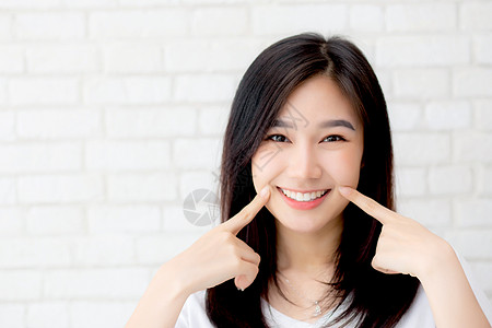 美丽的年轻的年轻亚洲女人的肖像 幸福站立人士成人皮肤手指商务女士灰色商业水泥女孩图片