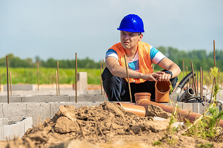 将塑料管铺在建筑物的根基上男性财产水泥建筑学项目工程领班工人工程师安全图片