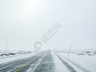 穿过暴风雪的暴风雪 用黑冰在路上 挪威森林黑冰风暴交通风景冻结国家季节小路乡村图片