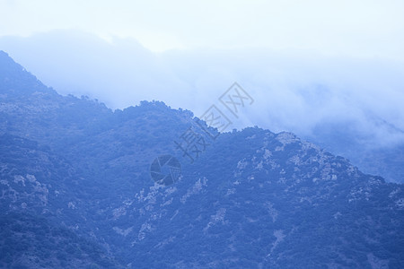 云层和森林环绕的高山岩石农村林业树木天空阳光天气公园风景旅行图片