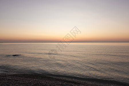 太阳升起在岩石海滩上海景反射阳光天空紫色海岸线天堂支撑辉光海岸图片