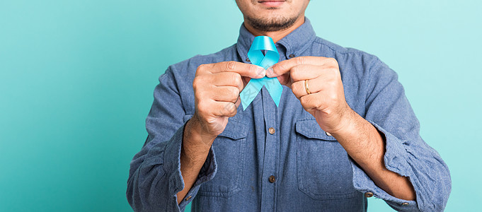 英俊男子装扮他拿着轻蓝丝带支持肿瘤学机构男人卫生疾病帮助丝带预防医院前列腺图片