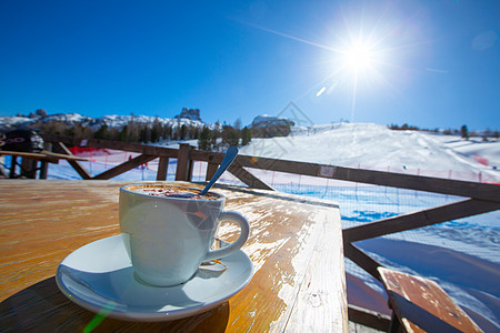 卡布奇诺咖啡在滑雪度假胜地咖啡馆咖啡厅高山咖啡店桌子太阳巧克力可可旅行闲暇运动假期图片