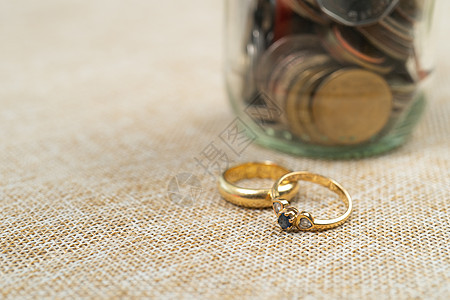 与库恩人结婚戒指在罐子里 为结婚节省了钱硬币金子婚姻夫妻新娘收益念日婚礼订婚生长图片