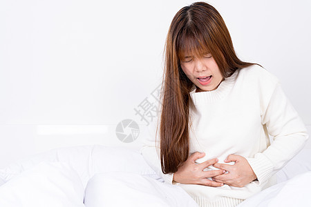 年轻妇女躺在床上胃痛 在医疗或日常生活概念上受到保健护理的治疗 第12条腹部腹痛经期成人疾病肚子女性痛苦女孩腹泻图片
