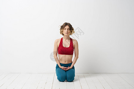 一名穿蓝牛仔裤的女子在室内浅背景和体操中做瑜伽 而且体操机身微弱训练力量健康专注女孩冥想运动身体活动工作室图片