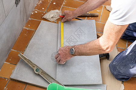 瓷砖在剪裁前先测量瓷砖工作陶瓷切割男人工匠瓦工安装维修地面建筑图片