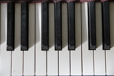 一把旧钢琴的灰色键图片