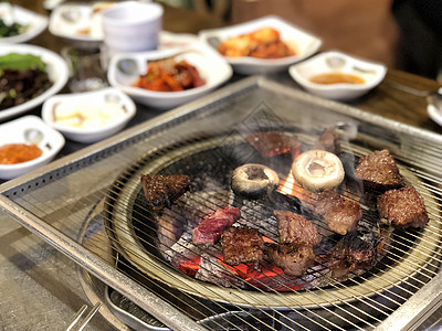 烧热煤炭上的烤肉 这种食物是韩国或日本的木炭美食餐厅猪肉牛肉筷子午餐奶牛盘子肋骨图片