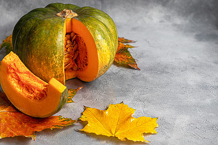 在灰色背景的新鲜南瓜与南瓜种子 秋季午餐概念 在一个木制的背景上 健康的饮食产品橙子孩子们面包果汁小屋奶油楔子蔬菜玻璃植物图片