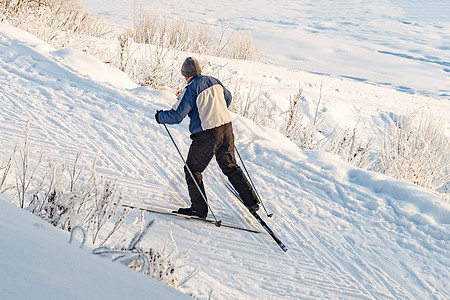 男性滑雪者攀登山峰图片