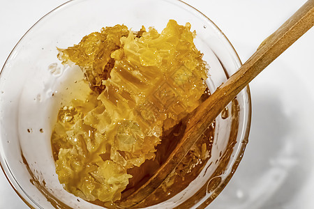 用木勺子在玻璃碗中的蜂蜜甜点早餐食物木头金子药品蜂蜡蜂窝糖浆梳子图片