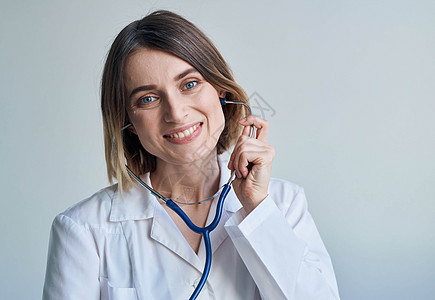 护士穿着医疗长袍和听诊器 在她的脖子上微笑画像女士医师药品医生专家外科女性快乐保健诊所图片