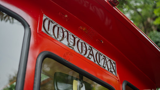 Coyoacan 在一辆红色特罗莱车上签字 底座上有布卢利树乘客树木人行道树叶交通工具交通天空城市民众运输图片