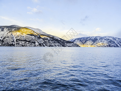 冬季风景和早晨的黄金日出 在Sognefjord挪威山脉蓝色山峰旅行时间反射颂歌天空太阳金子图片