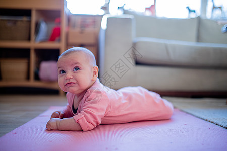 微笑的女婴躺在粉红鲁上婴儿孩子内饰育儿长椅俯卧姐妹童年窗户乐趣图片