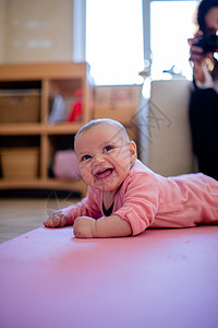 微笑的女婴躺在粉红鲁上童年肌肉女儿快乐乐趣手势窗户孩子小地毯表情图片