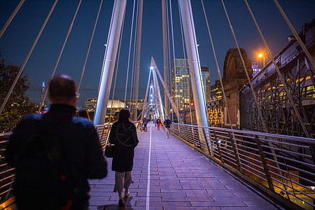 夜间在泰晤士河上白色桥上行走的步行者金属旅行市中心建筑电缆城市景观灯光行人建筑学图片