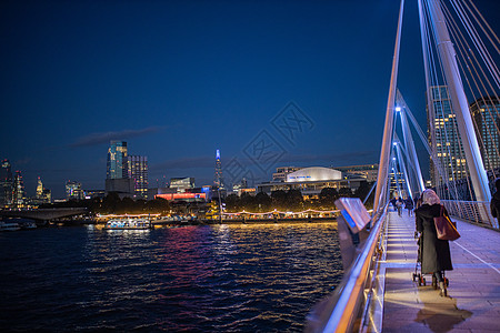 夜里从泰晤士河上一座白色桥的扶手处建筑天空口罩行人电缆城市旅游旅行景观反射图片