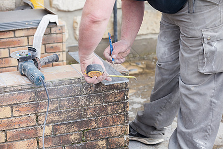 砖瓦的量度和打个记号来切割并铺一个瓷砖工具制品安装铅笔工作男人陶瓷装修工人斜角图片
