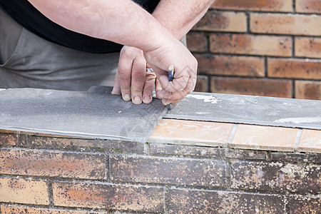 砖瓦的量度和打个记号来切割并铺一个瓷砖装修安装斜角陶瓷瓦工工人建造男人平铺建筑图片