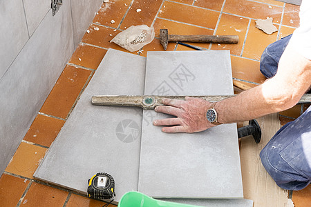 瓷砖在剪裁前先测量瓷砖工人石匠铅笔地板刀具建筑地面材料男人瓦工图片