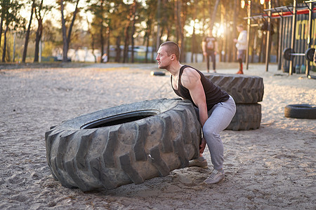 强力男子训练锻炼运动 在户外DY健身房举起大轮胎奉献运动员肌肉专注成人活力身体精神力量活动图片