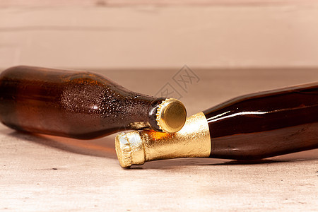 一瓶金发啤酒和一瓶安柏啤酒 倒在地上庆典金发女郎豪饮瓶子桌子琥珀色饮料酒吧气泡液体图片