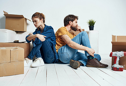 男女在新公寓中搬动修理工箱的物品沙发压力丈夫婚姻房间斗争女士妻子男性离婚图片