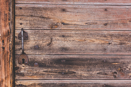 旧金属门 粗木木背景的敲门手图片