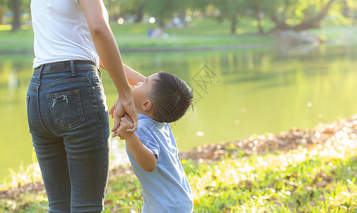 亚洲母亲或父母亲和儿子与爱牵手 i乐趣公园信仰闲暇家庭男生生活妈妈感情女士图片