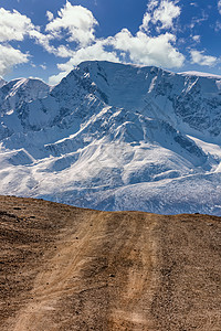 通往北丘伊斯基山脉雪山的高原公路的肖像尺寸景观 美丽的蓝色多云天空作为背景 阿尔泰山脉 西伯利亚 俄罗斯图片