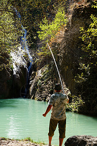 人类在山湖中钓鱼 有瀑布 后视男人娱乐闲暇成人爱好假期卷轴天空渔夫旅行图片