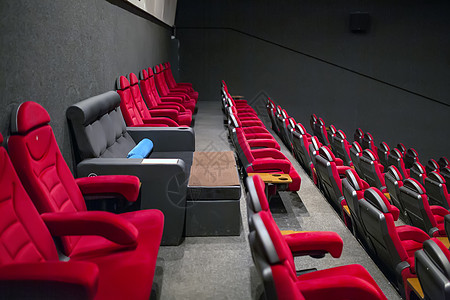 红椅间一间空的电影院里的贵宾座椅图片