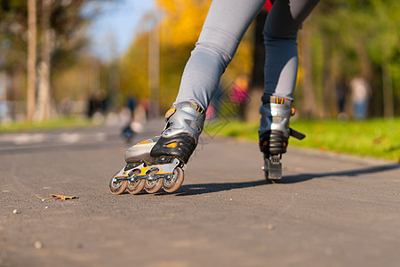 活跃的闲暇 一个运动的女孩在秋天滚滚女性青少年行动车轮街道刀刃旱冰乐趣锻炼爱好图片