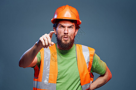 橙色硬帽子安全职业蓝底背景工作人员男性商业建筑学建造安全帽橙子成人头盔建筑工程师男人图片