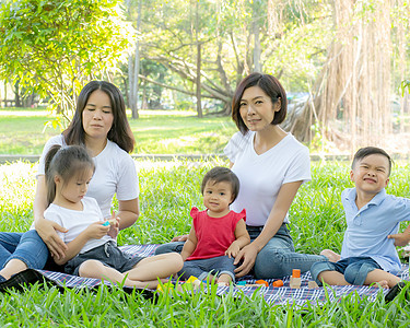 美丽的年轻年幼的亚洲家庭家长肖像 在公园野餐幸福活动女士孩子花园喜悦母亲成人房子快乐图片