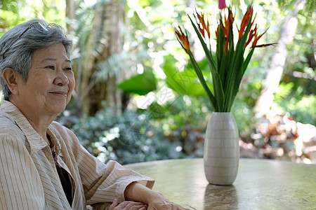 老年妇女在花园休息 老年女性在户外放松公园退休长老花园闲暇女士背景图片