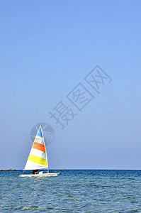 一艘有船长的彩色帆船在暑假期间在塞浦路斯海上航行海浪晴天海滩女性冲浪游泳衣天堂太阳蓝色女孩图片