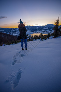 拍摄日落时冬湖山景的摄影师照片探险家旅行女士天空游客闲暇森林相机登山荒野图片