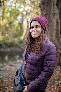 快乐的女士与宁静的笑容 站在森林里季节性绿色公园叶子荒野地面针织帽旅行沼泽树木图片