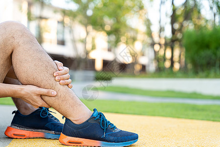 男性运动员腿部受伤和疼痛 手抓着痛苦的腿在公园里跑来跑去踪迹跑步抽搐伤害疾病训练赛跑者十字形小牛女士背景图片