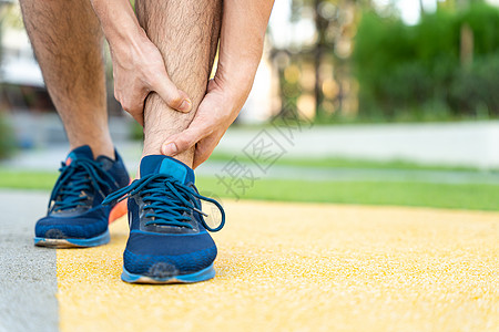 男性运动员腿部受伤和疼痛 手抓着痛苦的腿在公园里跑来跑去抽搐跑步女士踪迹运动十字形膝盖事故训练伤害图片