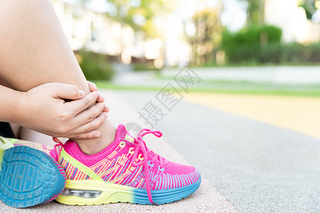 女性胖脚步运动员腿部受伤和疼痛 手抓着痛苦的腿在公园里跑来跑去小牛膝盖女士疾病跑步肌肉十字形抽搐训练治疗图片
