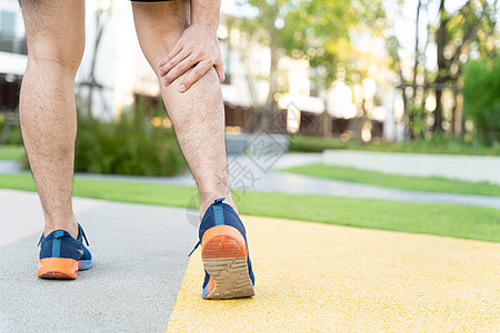 男性运动员腿部受伤和疼痛 手抓着痛苦的腿在公园里跑来跑去小牛事故踪迹疾病膝盖慢跑者跑步女士女性肌肉图片